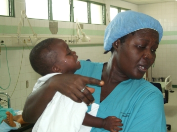Ghanaian nurse comforts a child prior to surgery